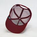 Ein Produktfoto, das die Innenansicht einer weinroten Trucker-Kappe auf einem weißen Hintergrund zeigt. Der Fokus liegt auf der inneren Konstruktion, dem atmungsaktiven Mesh-Gewebe und dem verstellbaren Snapback-Verschluss am hinteren Teil.