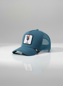Ein professionelles Produktfoto einer blauen Trucker-Kappe. Auf der Vorderseite befindet sich ein quadratischer Aufnäher, der einen Hahn und den Schriftzug "GICKERL" zeigt. Die Kappe steht auf einer spiegelnden Oberfläche vor einem hellen Studiohintergrund, was eine deutliche Reflexion erzeugt.