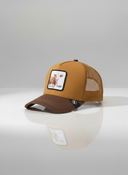 Eine braune Trucker-Kappe mit "KUAH"-Aufnäher, fotografiert in der Seitenansicht vor einem weißen Hintergrund. Diese Ansicht zeigt deutlich die hellbraune Vorderseite, den dunkelbraunen Schirm und den passenden Mesh-Einsatz am Hinterkopf.